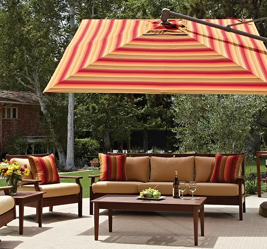Outdoor patio seating set with sofa, chairs, coffee table, and striped umbrella in backyard